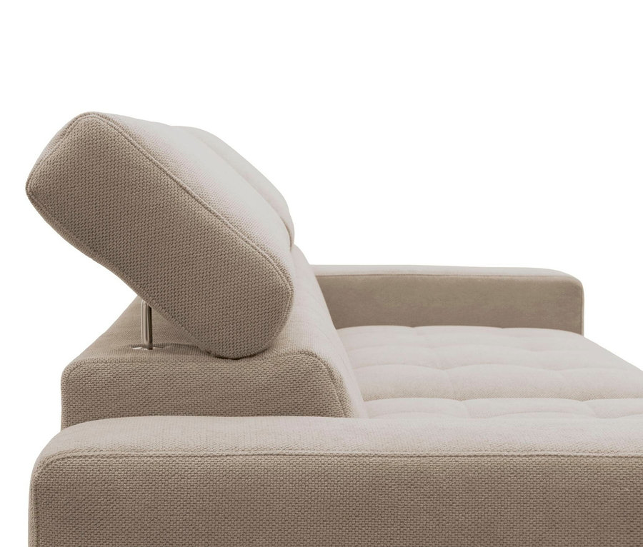 Nahaufnahme eines hellbeigen Sofas mit einer erhöhten, verstellbaren Kopfstütze, die von einer Metallstange gestützt wird. Das Sofa hat getuftete Sitzkissen und eine gewebte Stofftextur.