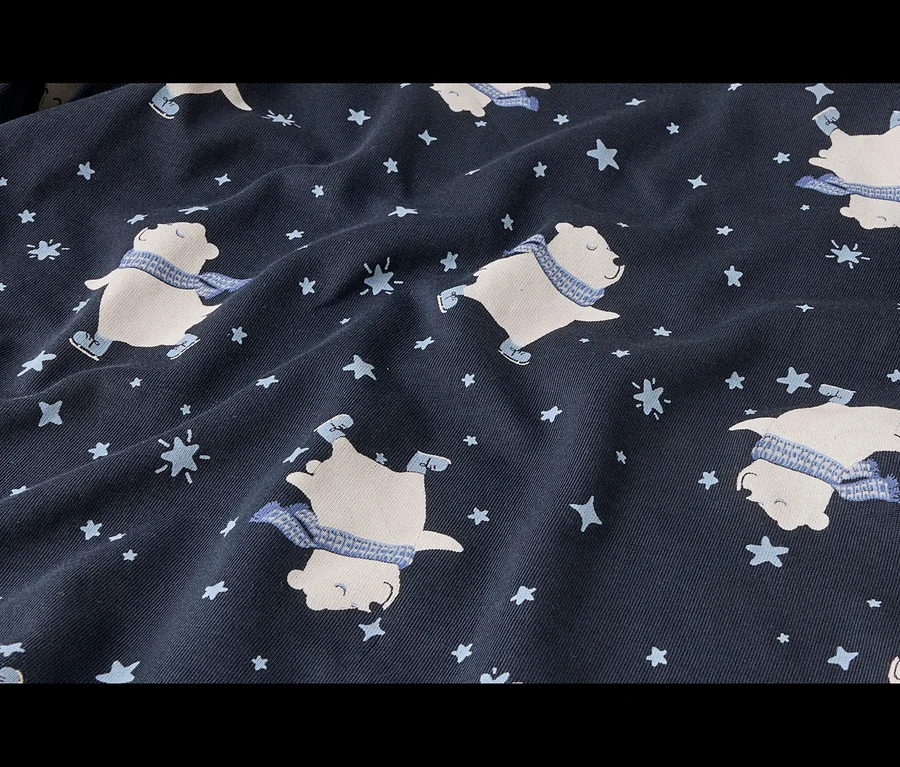 Dunkelblauer Stoff mit einem Muster aus weißen Eisbären mit blauen Schals und Schlittschuhen, umgeben von hellblauen Sternen und Schneeflocken.