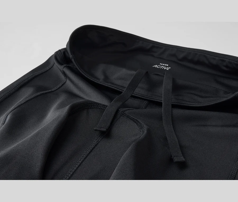Schwarze Sporthose mit Kordelzug und sichtbaren Nähten. Das Tchibo Active Logo ist im Bund zu sehen.
