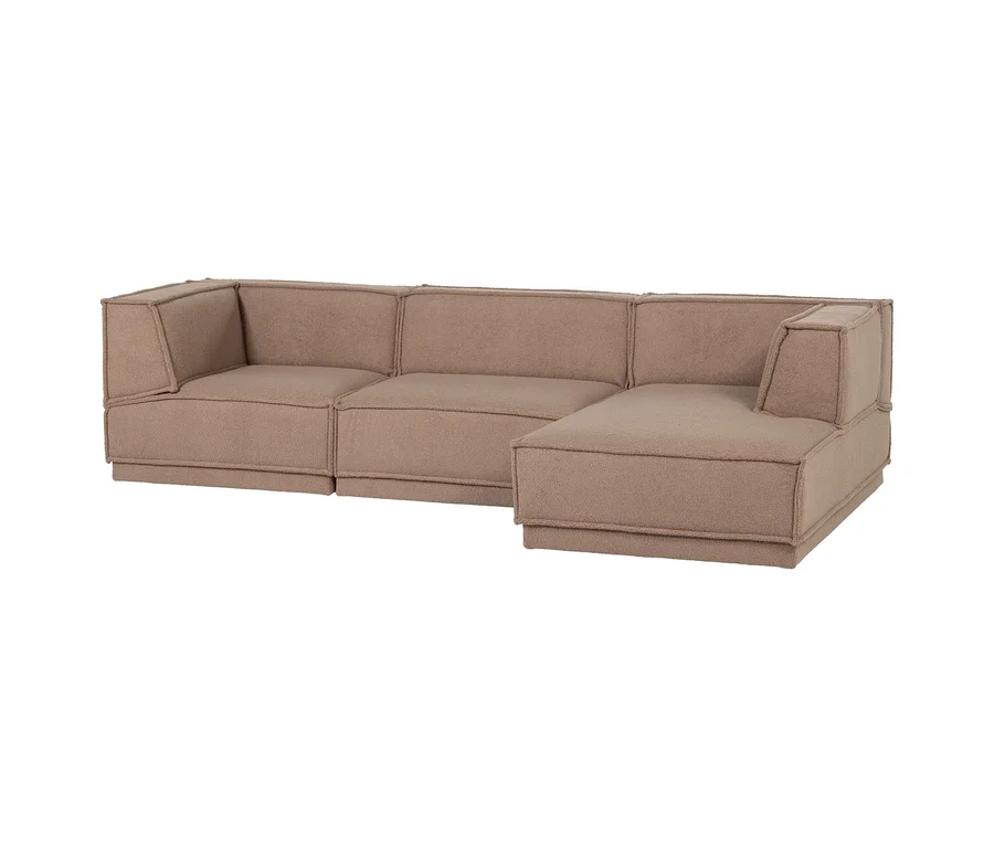 Ein L-förmiges Ecksofa in Hellbraun mit strukturierter Oberfläche und sichtbaren Nähten.