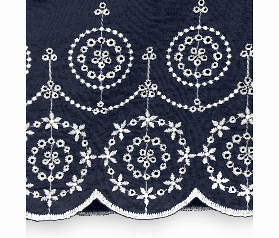 Detailansicht eines blauen Shirts mit Lochstickerei.