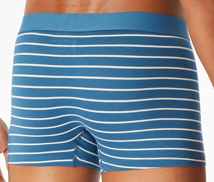 Mann posiert in blau gestreiften Boxershorts mit weißen Streifen.