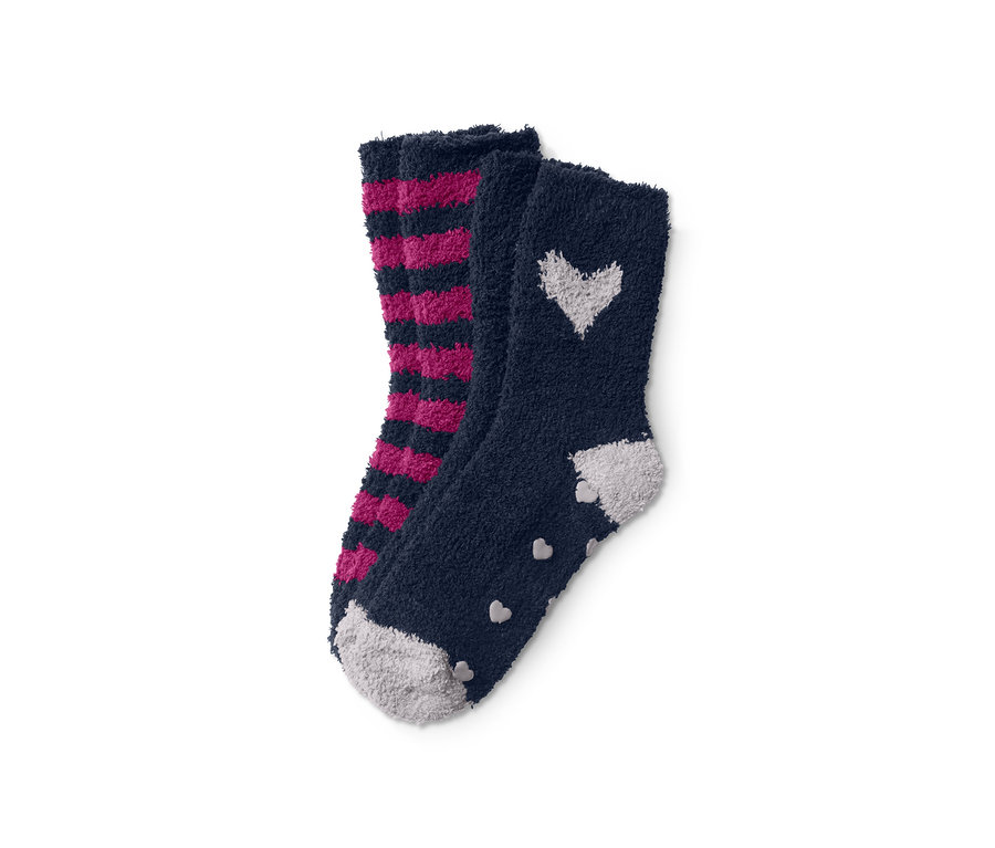 Zwei Paar flauschige Kuschelsocken: ein Paar gestreift in Pink und Schwarz, das andere marineblau mit weißen Herzen.