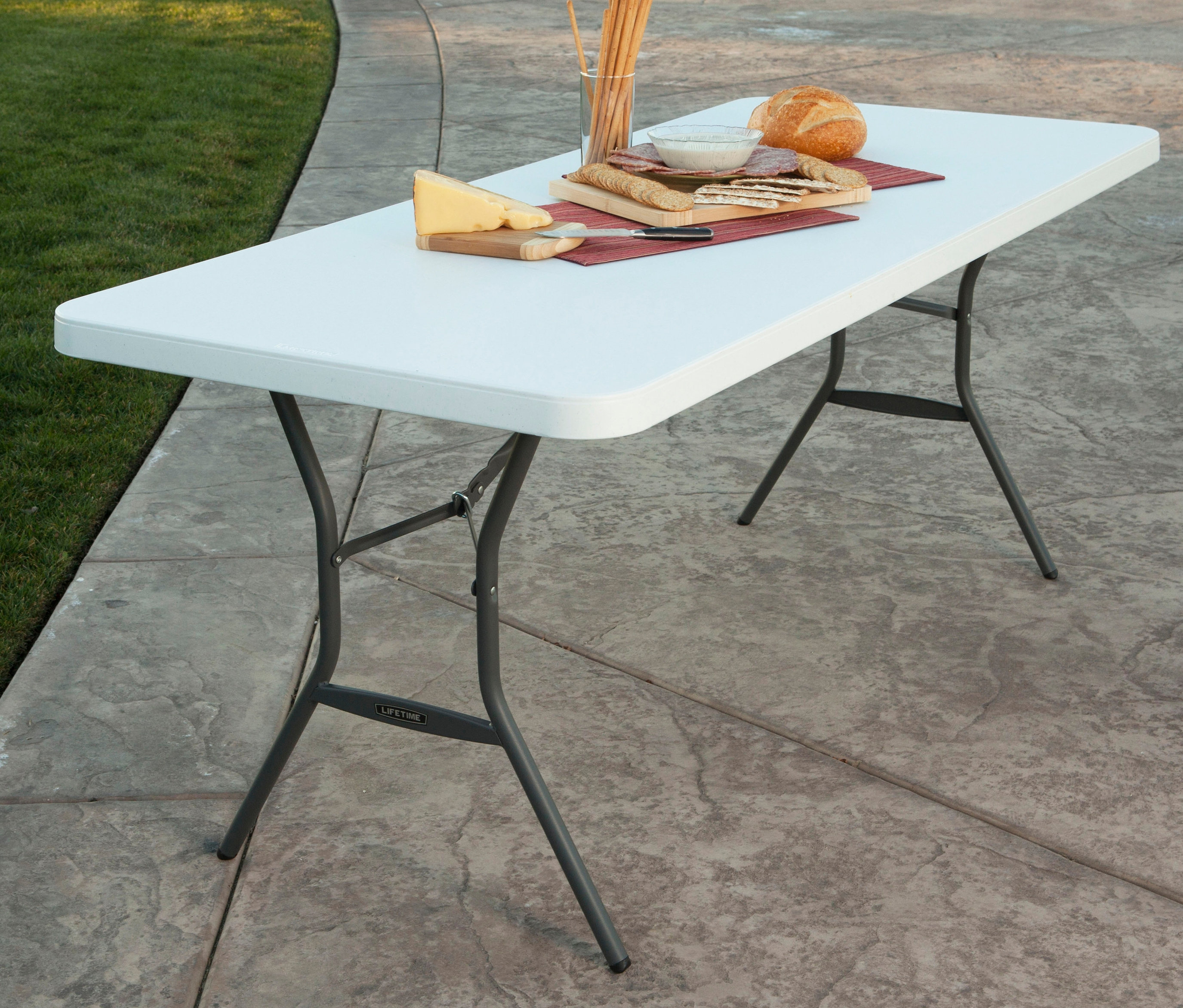 Essen auf einem weißen Lifetime-Kunststoff-Klapptisch im Freien.