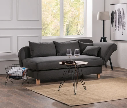 Wohnzimmer mit grauer Recamiere »Saturn« mit Stauraum, Tisch mit Weingläsern und Bücherregal.