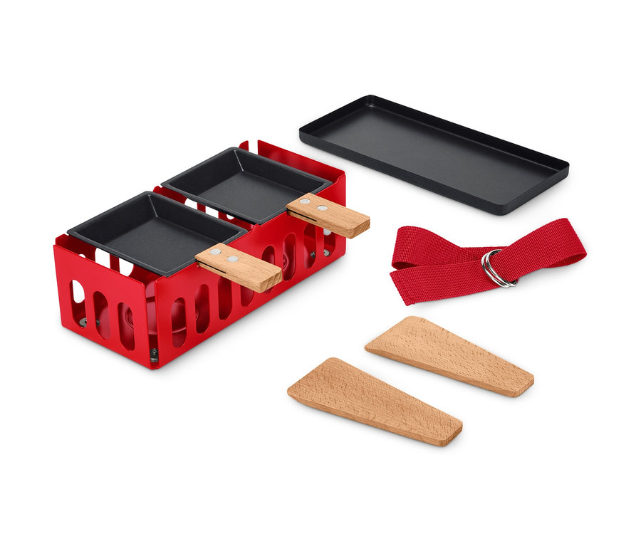 Ein roter Raclette-Grill für 2 Personen mit schwarzen Pfannen und Holzspateln.