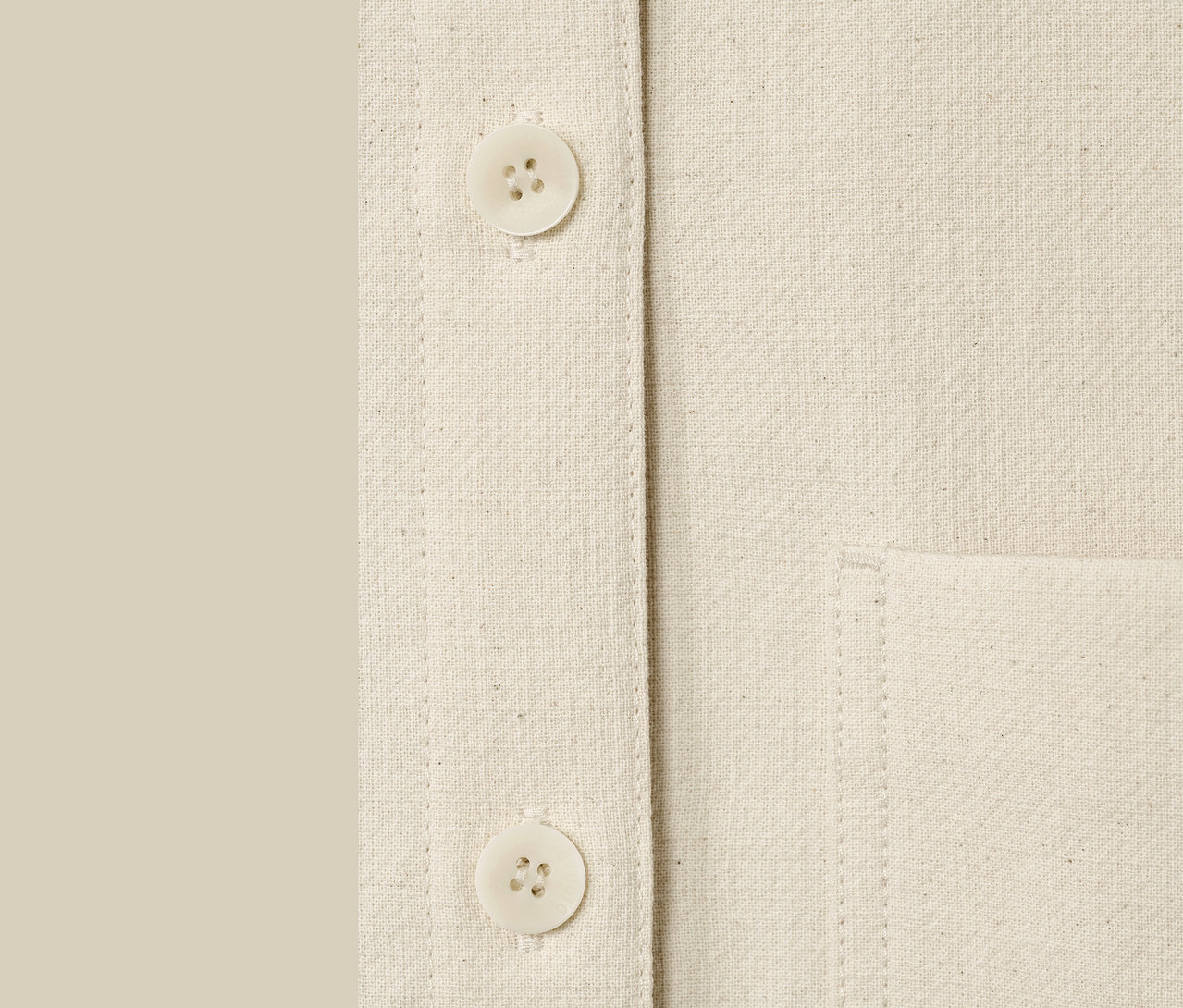 Detailaufnahme einer ungefärbten NAH/STUDIO Blusenjacke mit Knöpfen und Tasche.