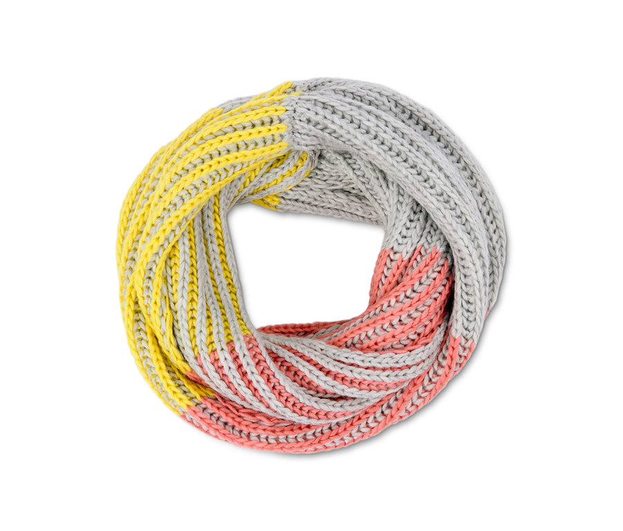 Ein Strickschlauchschal in Gelb, Grau und Rosa liegt gewickelt da.