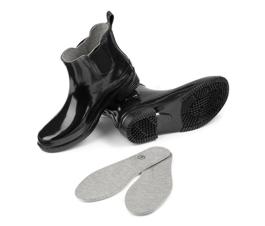 Schwarze Regenstiefeletten und graue Einlegesohlen auf weißem Hintergrund.