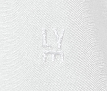 Detail einer weißen Hemdbluse mit gesticktem LY-Logo.