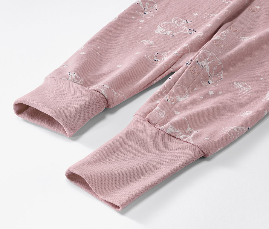 Detailaufnahme eines rosa Baby-Pyjamas mit Eisbärenmuster.
