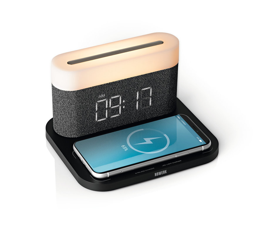 Schwarzer N8WERK Nachttischlampen-Wecker mit Wireless Charger zeigt 09:17 und lädt ein Telefon.