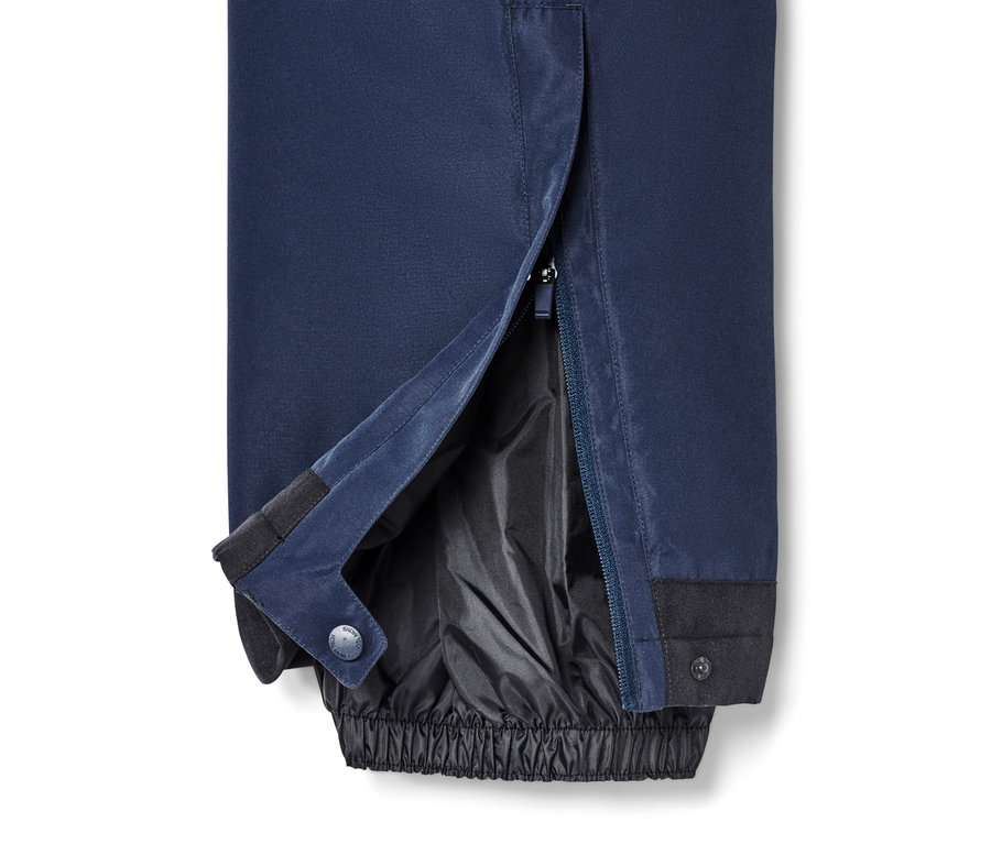 Detailansicht einer blauen Skihose mit offenem Reißverschluss am Bein.