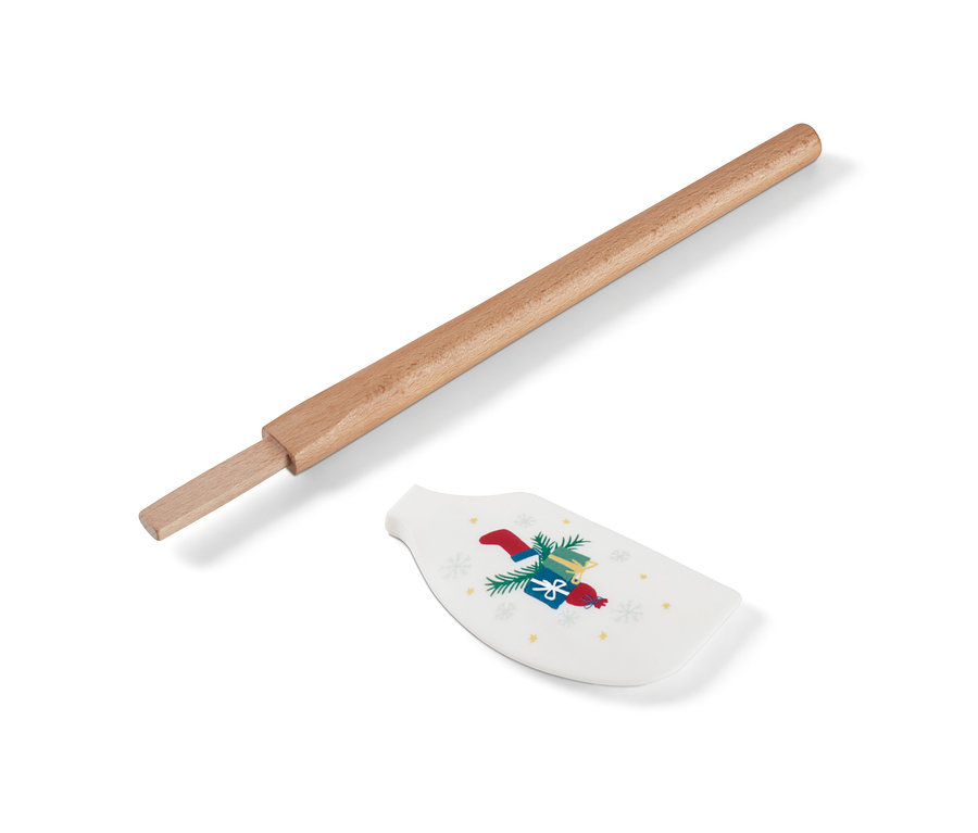 Ein zerlegter Teigschaber mit Holzgriff und einem weißen Silikonkopf mit Weihnachtsmotiv.