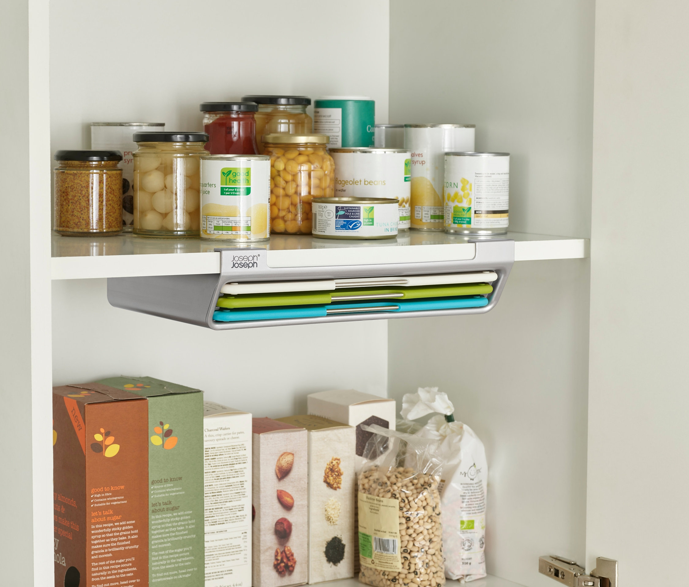 Regal mit Lebensmitteln und Joseph Joseph Schneidebrett-Set »Folio Slim«.