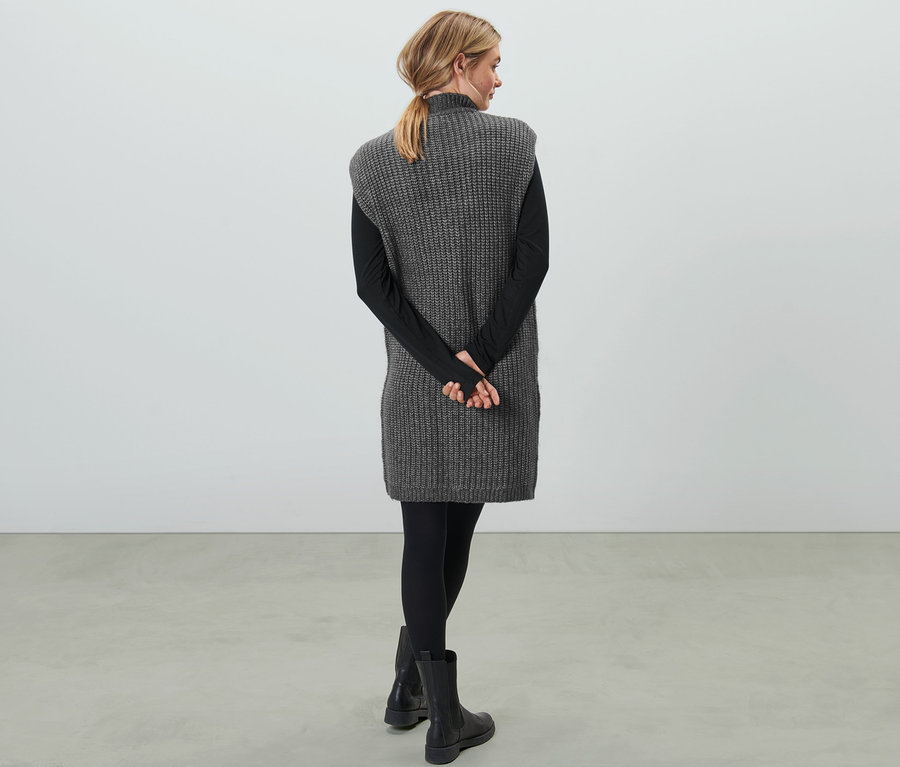 Frau mit dem Rücken zur Kamera trägt ein Strickkleid.