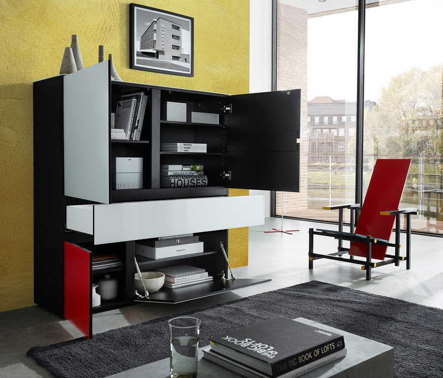 Schwarzes, weißes und rotes Highboard »Ideeus« mit offenen Türen steht im Wohnzimmer.