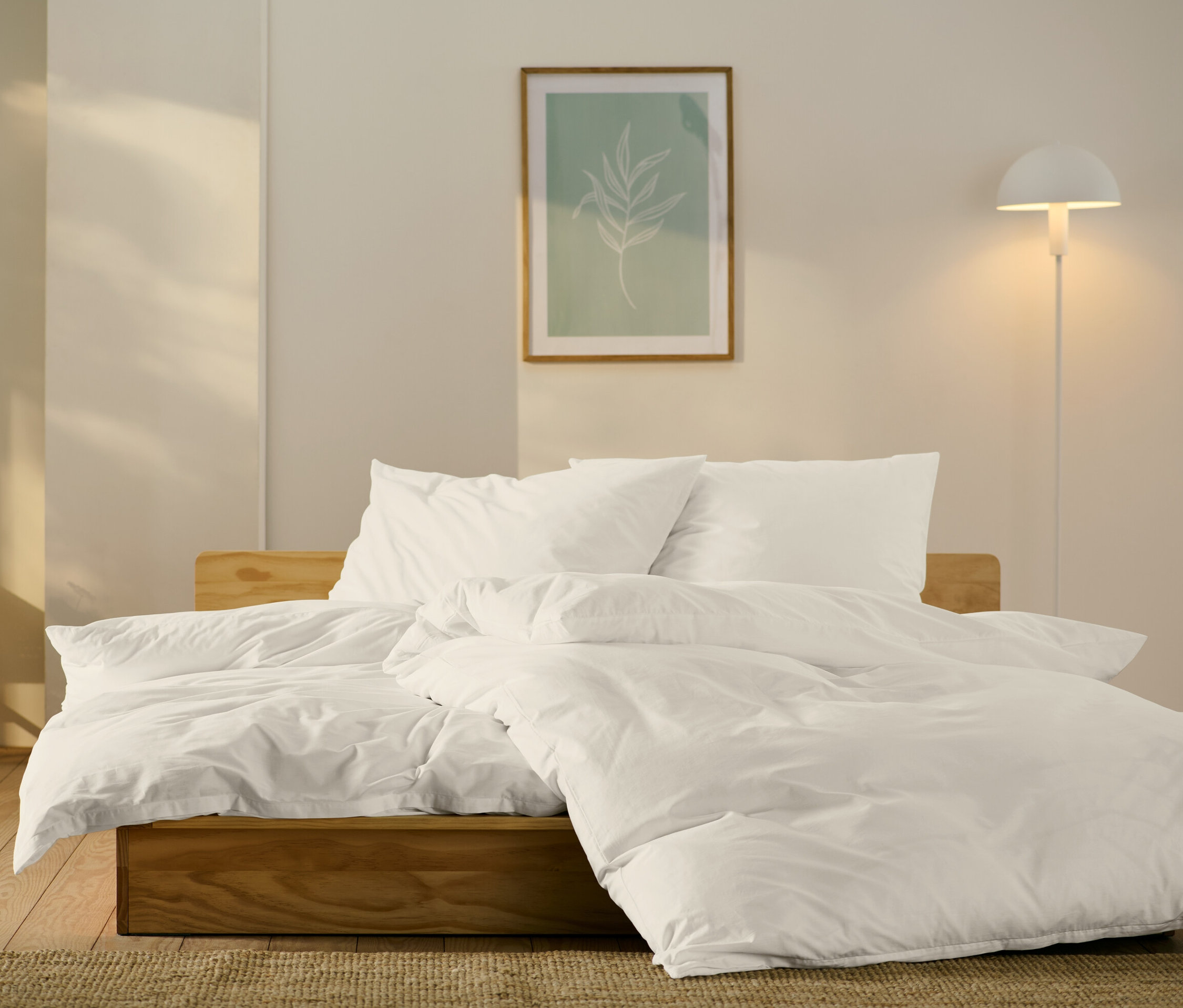 Bett mit weißer Perkal-Bettwäsche in Standard- und Übergröße.