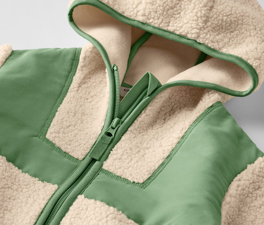 Detailansicht einer Kinder-Teddy-Jacke mit Reißverschluss und Kapuze.