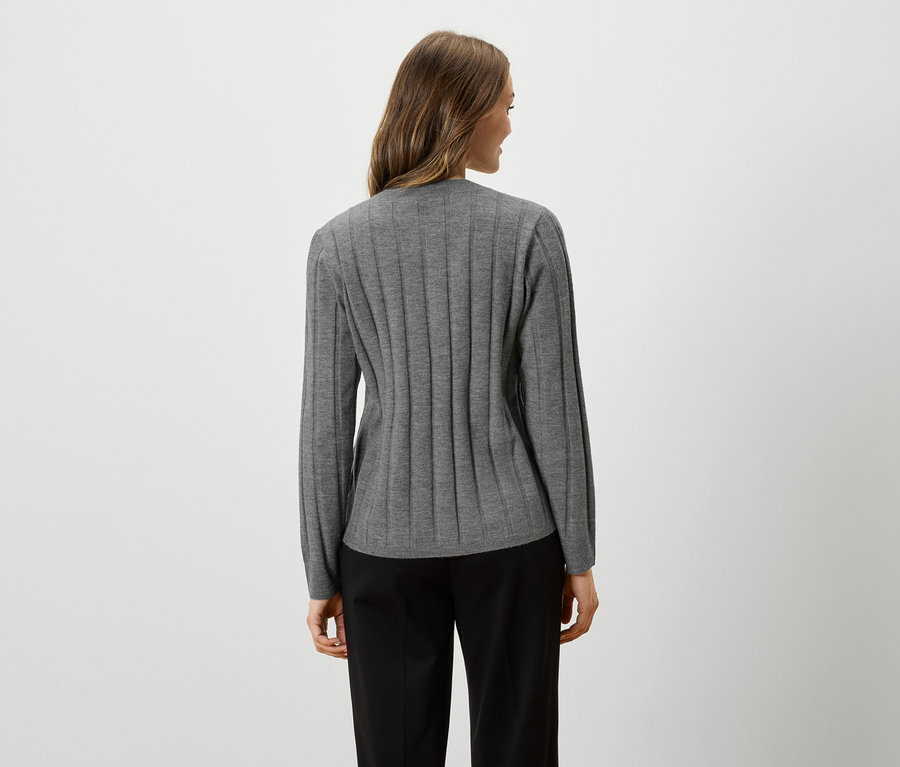 Frau von hinten in grauem, langärmligem Oberteil und schwarzer Hose.