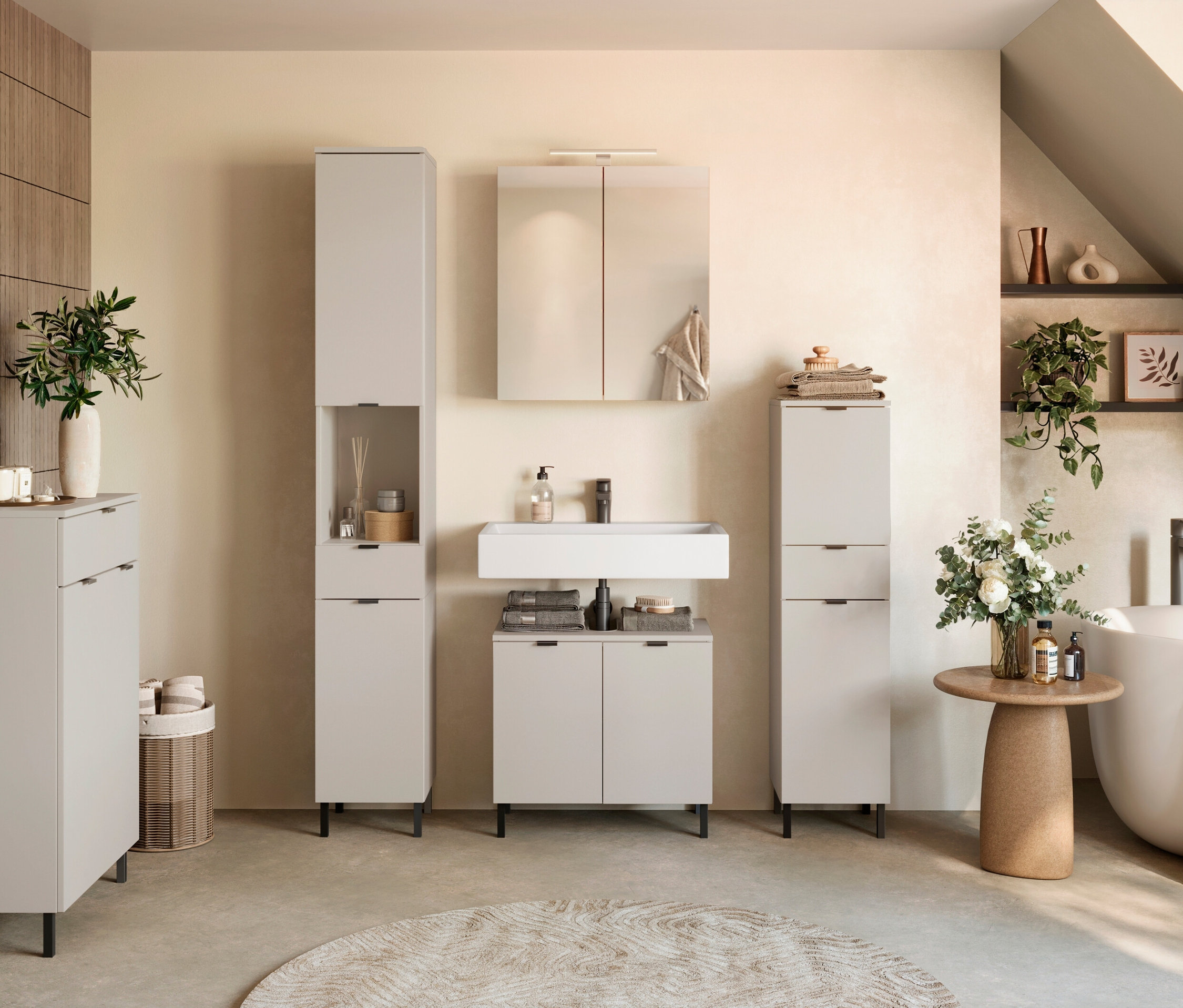 Ein Badezimmer mit weißen Möbeln, Waschbecken, Spiegel und Badewanne.