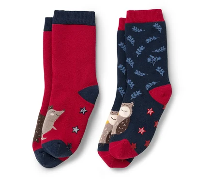Zwei Paar Kinder-Antirutsch-Socken: ein rotes Paar mit Fuchs und Sternen, ein blaues Paar mit Eulen und Blättern.