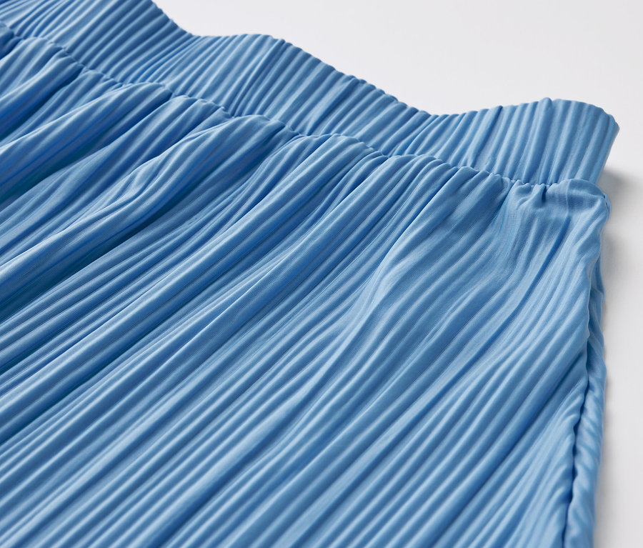 Detailansicht eines blauen Plisseerocks.