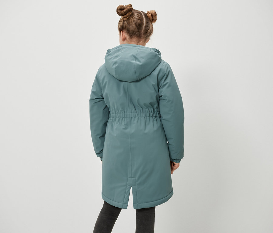 Rückansicht eines Mädchens mit Duttfrisur, das eine Kinder-Thermoparka trägt.