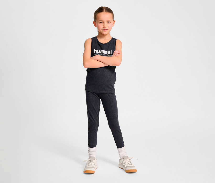 Mädchen steht mit verschränkten Armen und trägt ein HUMMEL HMLJR Top.