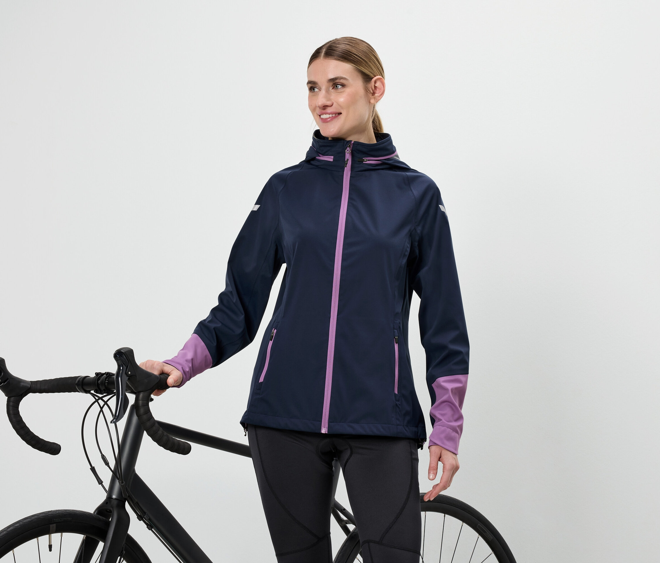 Frau in Jacke hält Fahrradlenker.