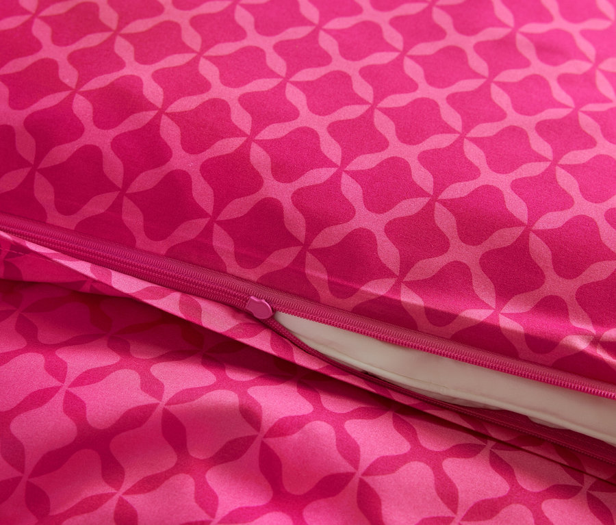 Detailansicht von pinkfarbener Microfaser-Bettwäsche mit Muster und Reißverschluss.