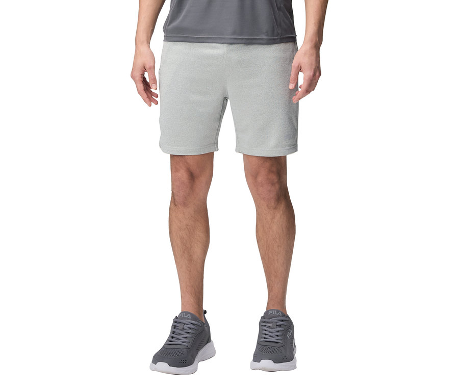 Mann trägt graue Shorts und graue Fila-Sneakers.