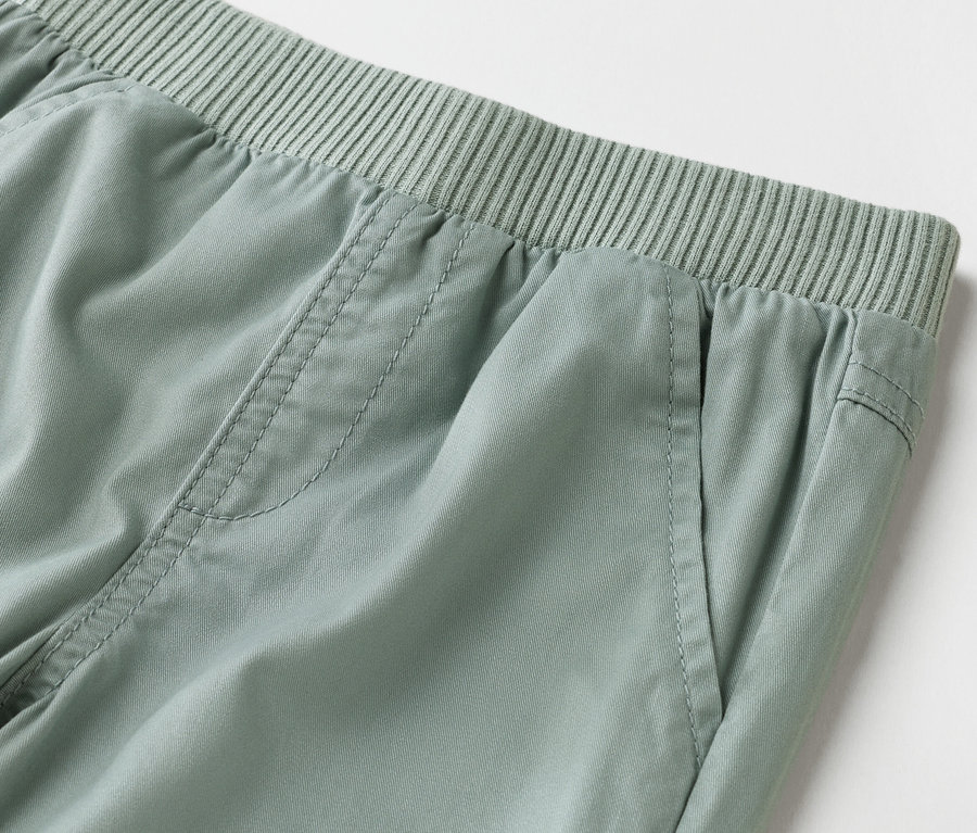 Nahaufnahme von hellgrünen Hosen mit elastischem Bund.