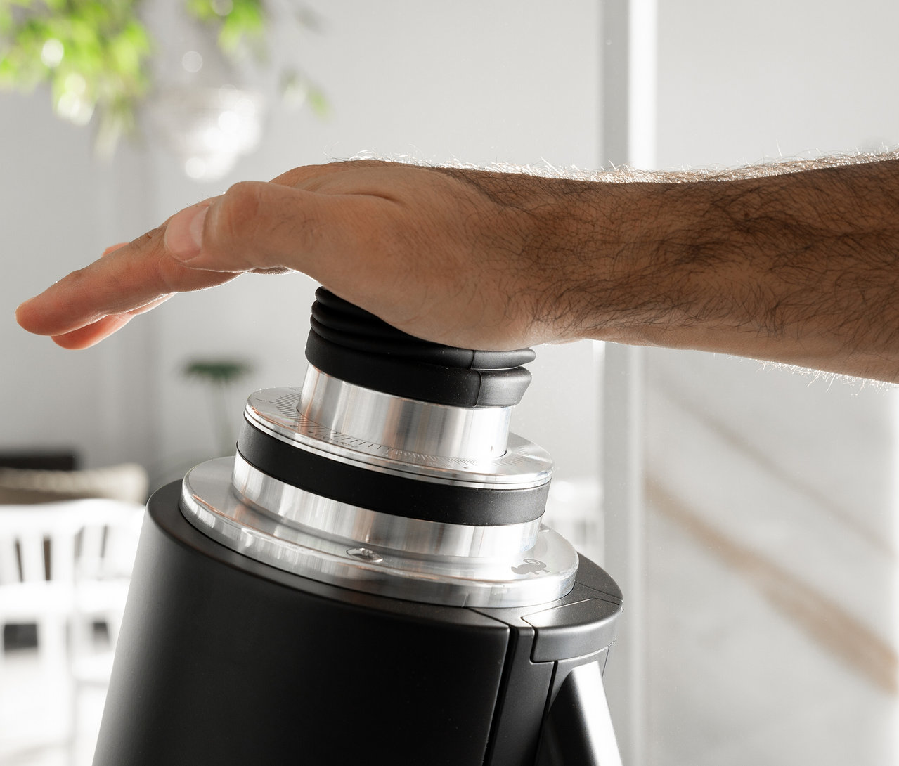 Eine Hand drückt auf einen schwarzen und silbernen Knopf.