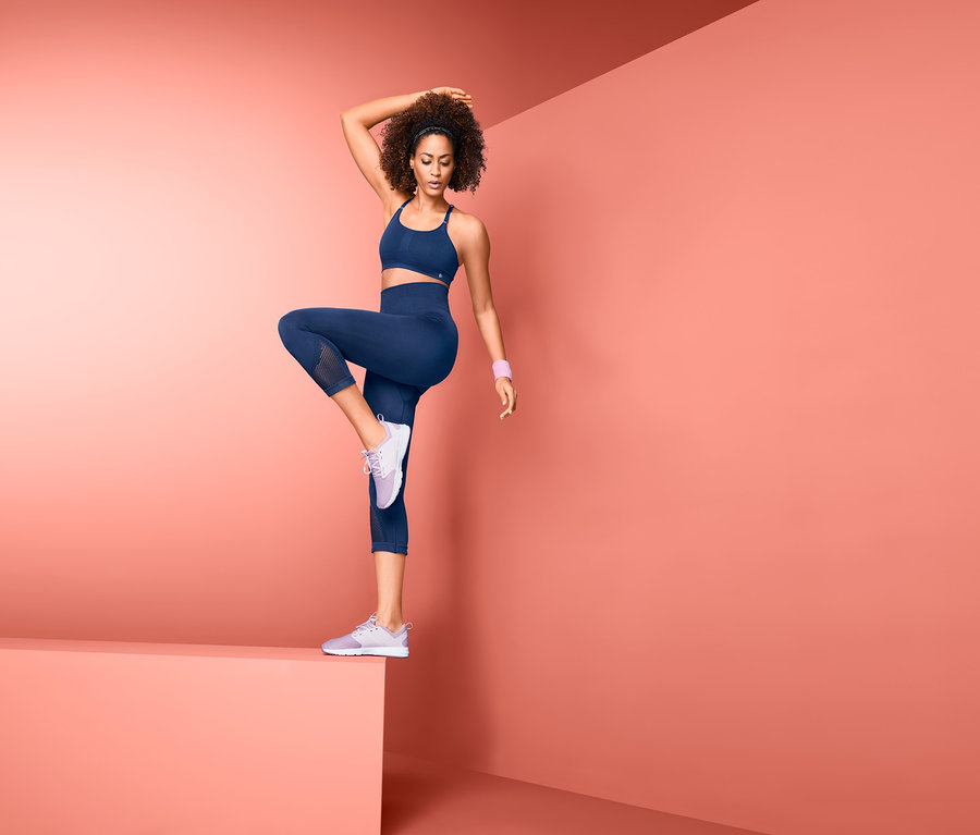 Frau posiert in Seamless-3/4-Sporttight und Sport-BH.