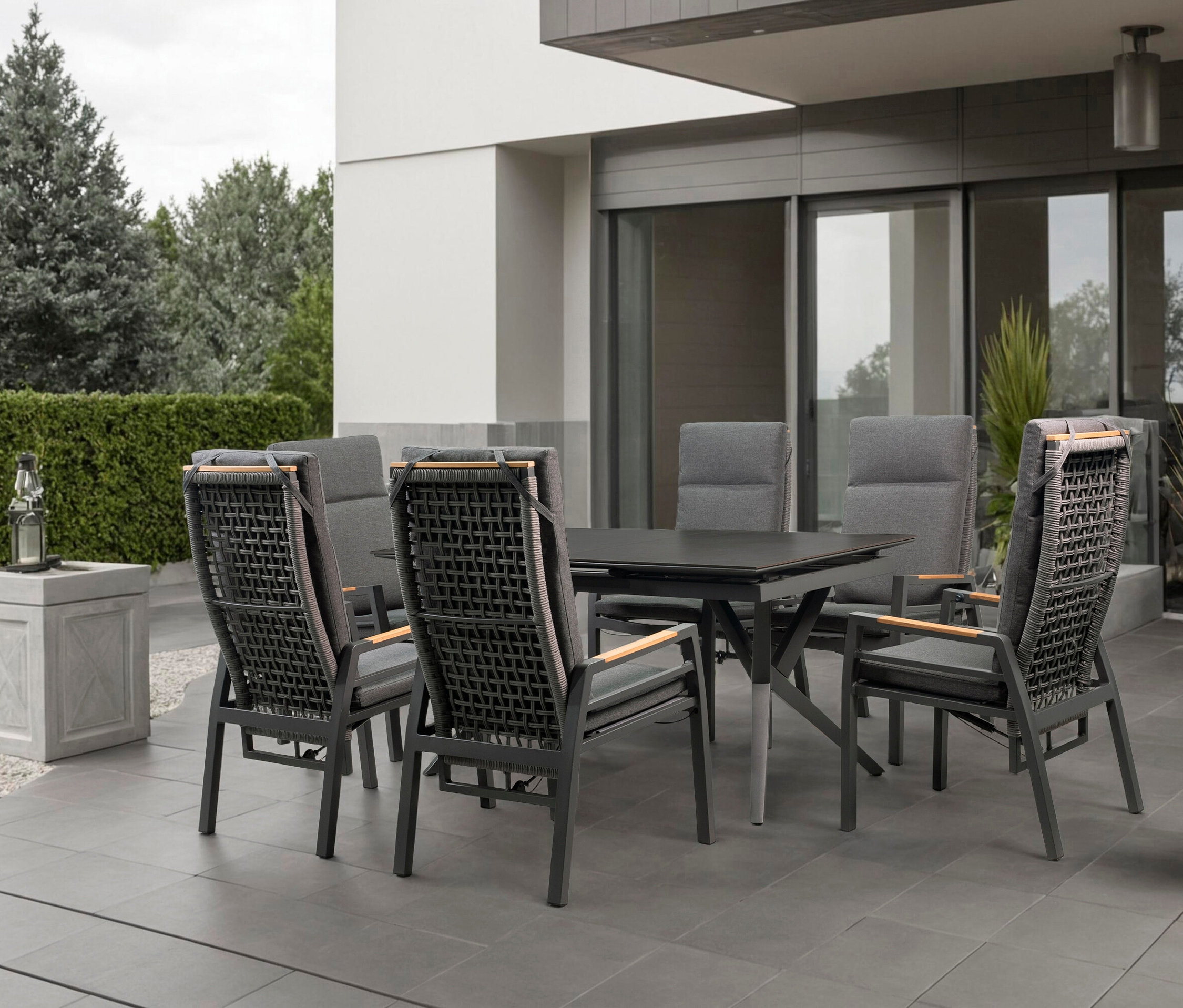 Gartentisch mit sechs Stühlen auf einer Terrasse.