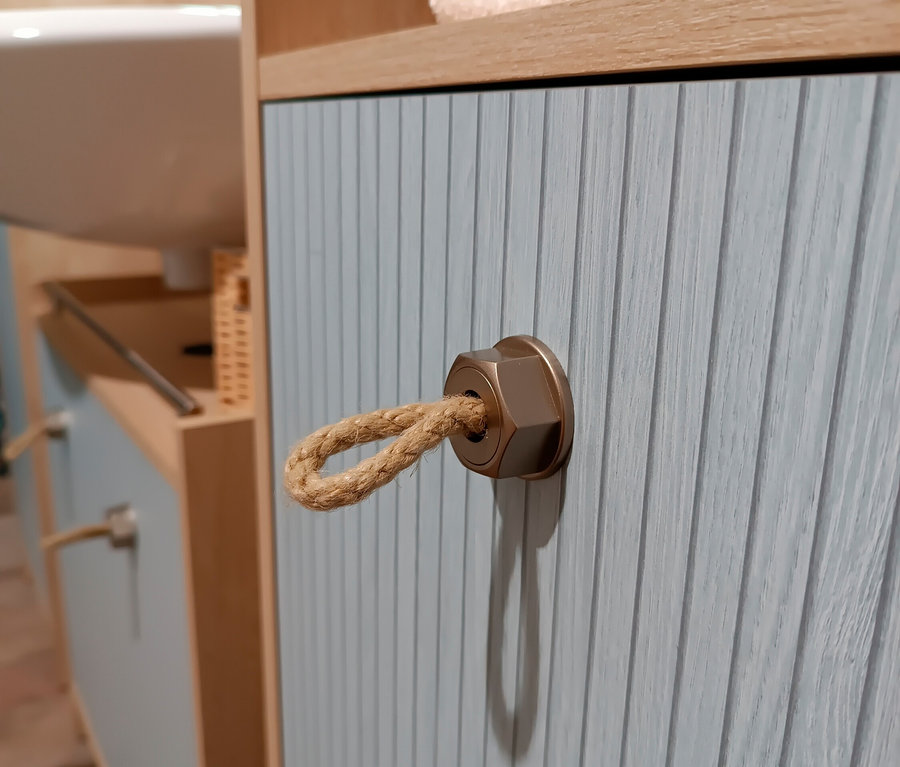 Detailaufnahme vom Badezimmer: Waschtisch »Sonderby« in Nordic Blue Oak mit Seil-Griff, Hochschrank »Sonderby« in Nordic Light Oak und Handtücher.