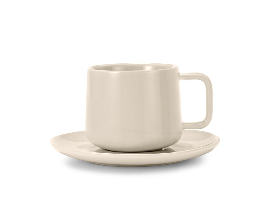 Eine cremefarbene Tasse steht auf einer Untertasse.