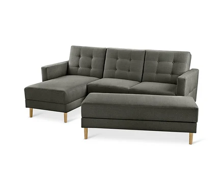 Graues Federkern-Ecksofa »Just Relax« mit getufteter Rückenlehne und separater Stauraumbank, auf hellen Holzbeinen.