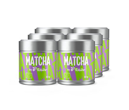 Sechs silberne Dosen Tchibo Matcha Tee mit grün-violetten Etiketten, auf denen „MATCHA by Tchibo“ und „30g“ sowie ein Bio-Logo zu sehen sind.