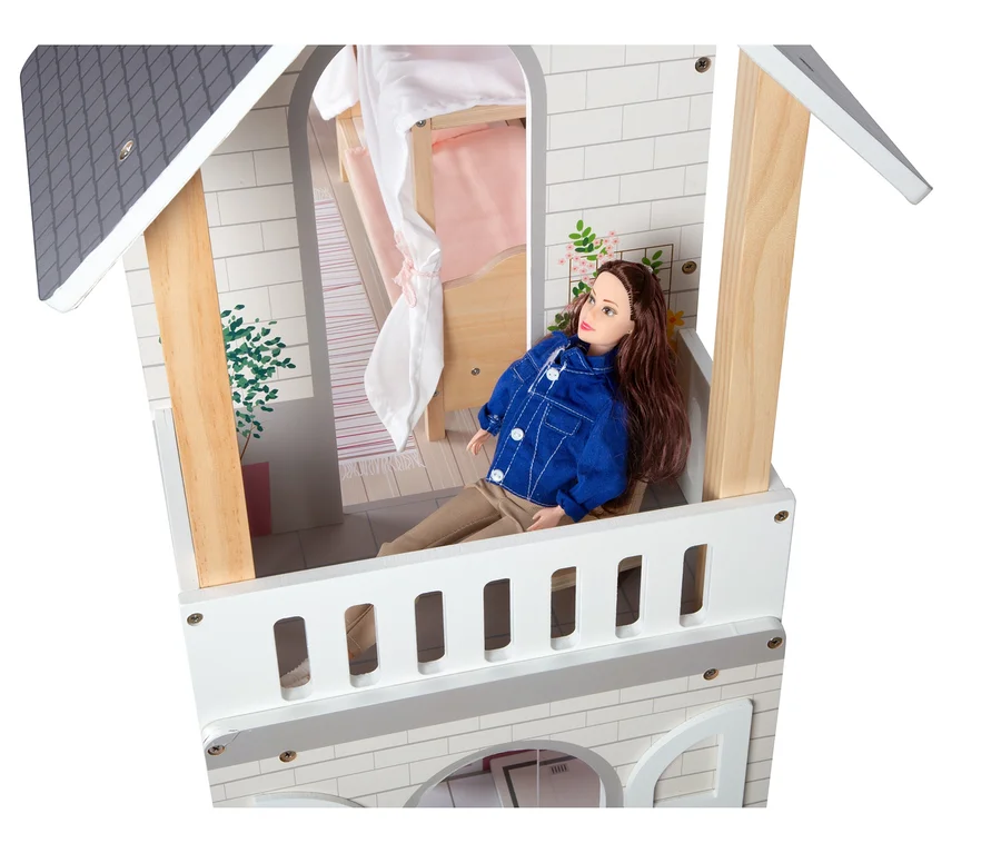 Puppe sitzt im small foot Puppenhaus Stadtvilla.