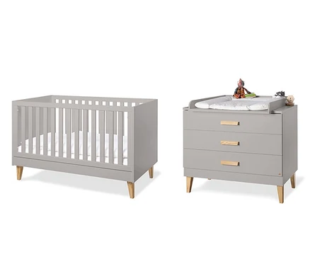 Ein Kinderzimmer mit einem grauen Kinderbett und einer Kommode mit Wickelaufsatz. Zu sehen ist das Pinolino Baby-Zimmer »Jasper«, 2-teilig.