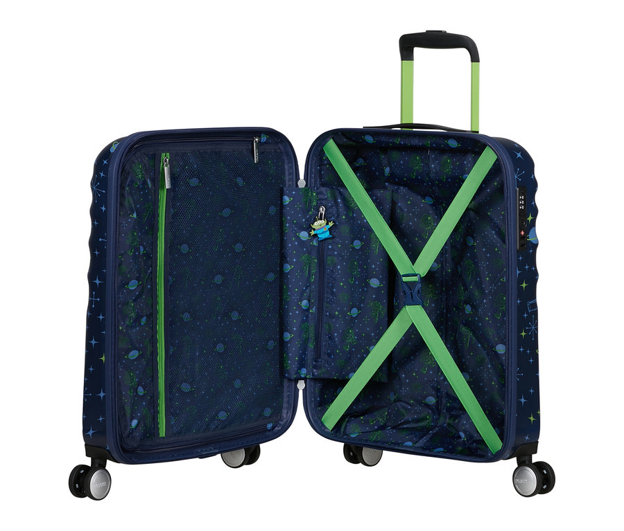 Ein offener, dunkelblauer Koffer mit Weltraummuster aus Sternen und grünen Aliens. Innen links eine Netztasche, rechts grüne Kreuzspanngurte und ein Alien-Schlüsselanhänger.