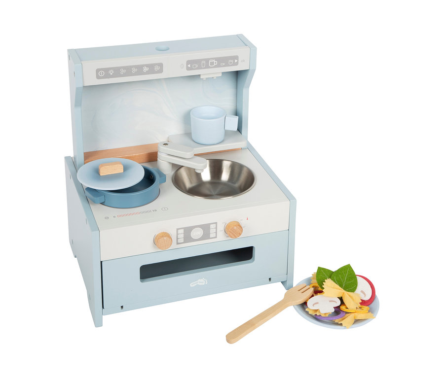 Eine hellblaue und weiße small foot Tabletop-Kitchen mit Topf, Tasse und Spüle. Daneben ein Teller mit Spielzeug-Nudeln und Gemüse.