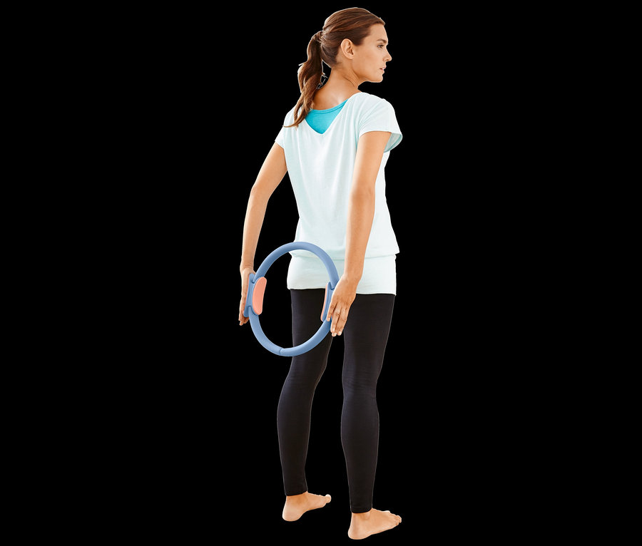 Frau hält einen Pilatesring.