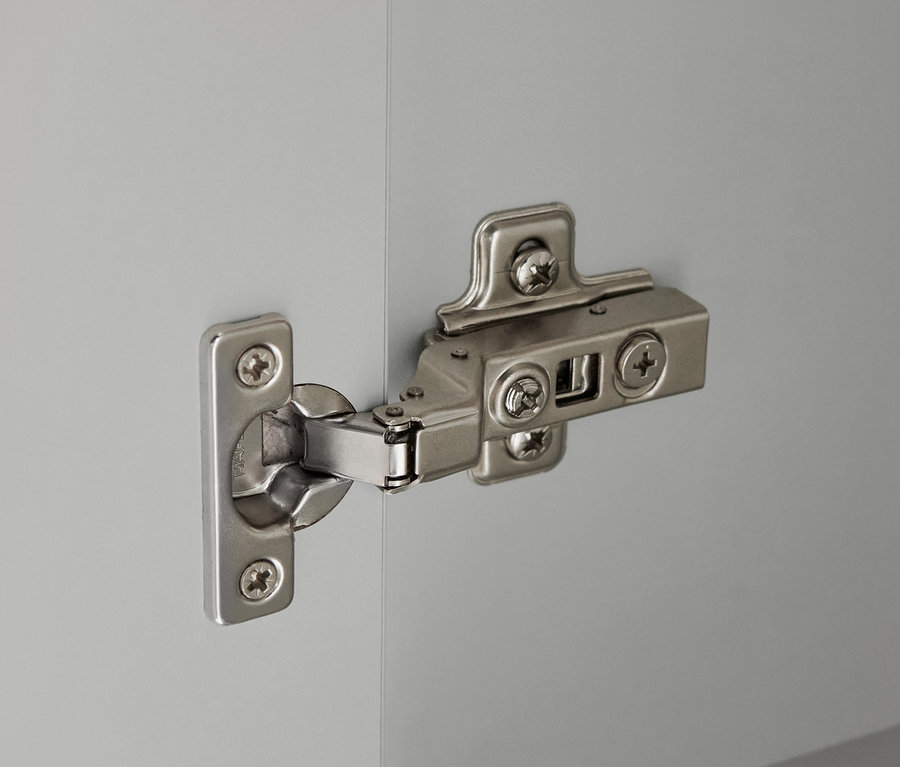 Detail eines silbernen Scharniers an einem hellgrauen Bad-Hochschrank »Eklund«.
