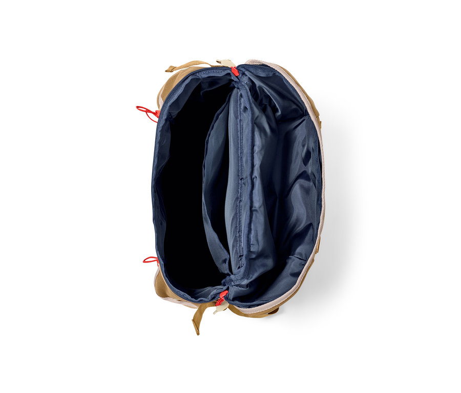 Geöffneter Outdoor-Rucksack in Beige mit marineblauem Innenraum.