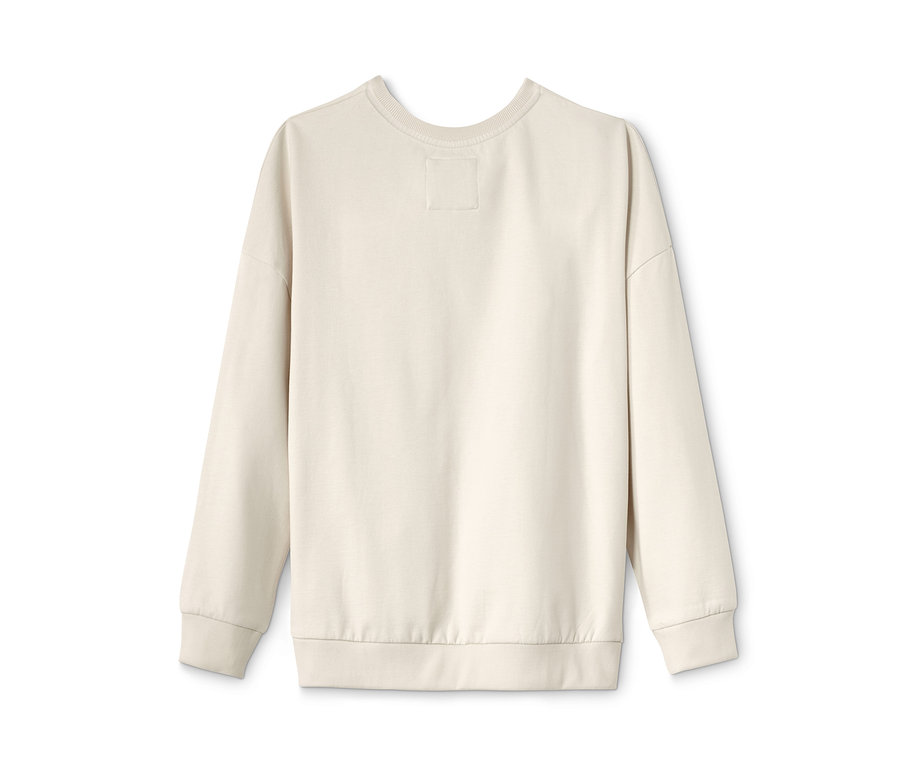 Ein cremefarbenes Sweatshirt mit Strassblumen liegt auf einem weißen Hintergrund.