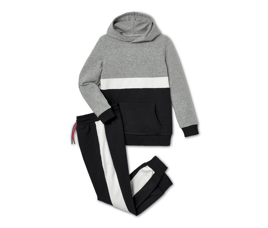 Eine grau, weiss und schwarz farbige Sweat-Kombi, 2-teilig, liegt auf einem weißen Hintergrund.