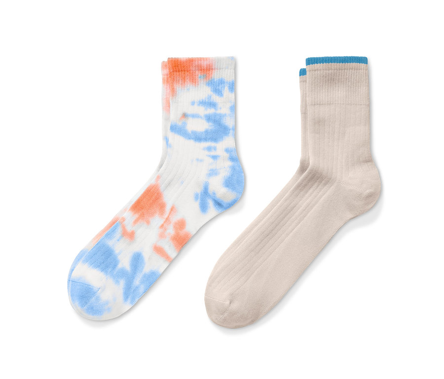 Zwei Paar Socken: ein Paar weiße Socken mit orange-blauem Batikmuster und ein Paar beige Socken.